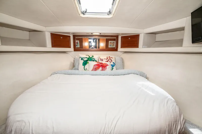 Slide: The Image of Luxurious bedroom interior of 1999 Riviera 48 Convertible yacht with elegant bedding and wood accents. - 43