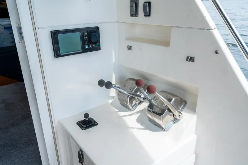Slide: The Image of Control panel of a 1999 Riviera 48 Convertible yacht with throttle levers and navigation display. - 24