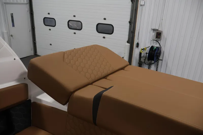 Slide: The Image of 2026 Four Winns H4 boat interior with tan leather seating in a garage setting. - 43