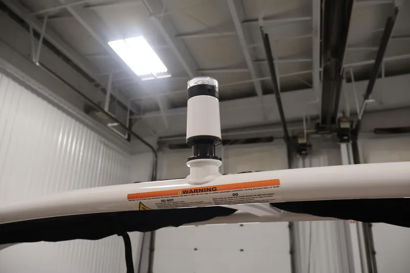 Slide: The Image of 2026 Four Winns H4 boat detail in a garage, featuring a mounted light and warning label. - 45