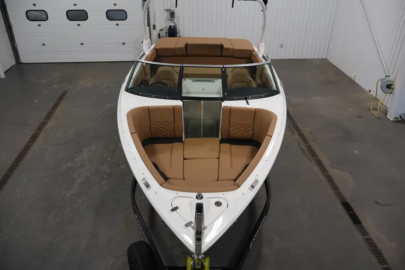 Slide: The Image of 2026 Four Winns H4 boat with tan seating, viewed from above in a garage setting. - 8