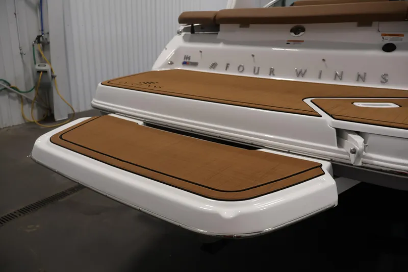 Slide: The Image of 2026 Four Winns H4 boat with teak swim platform in a garage setting. - 51