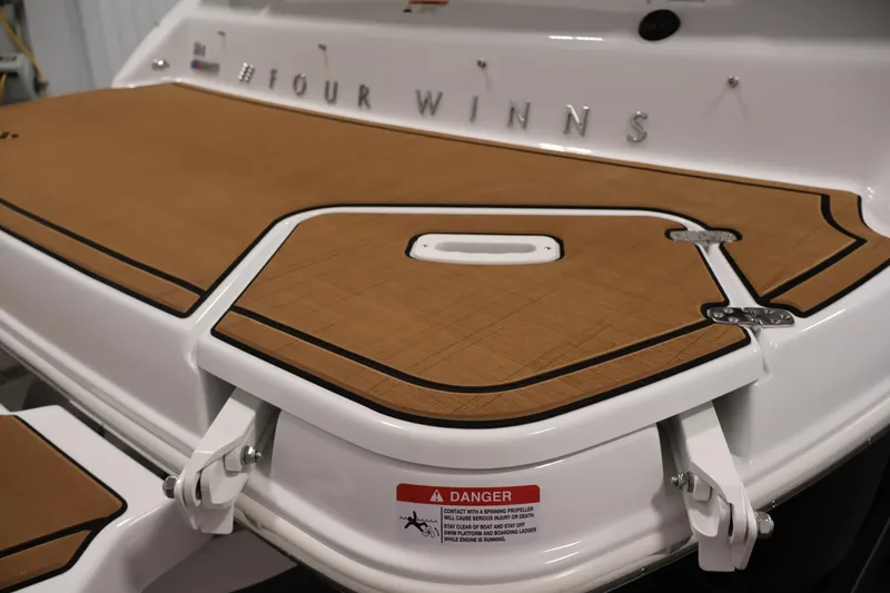 Slide: The Image of 2026 Four Winns H4 boat with teak-style swim platform and safety warning label. - 49