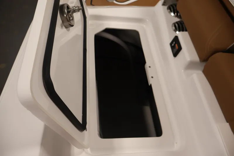 Slide: The Image of Open storage compartment on 2026 Four Winns H4 boat, featuring sleek design and brown seating. - 44