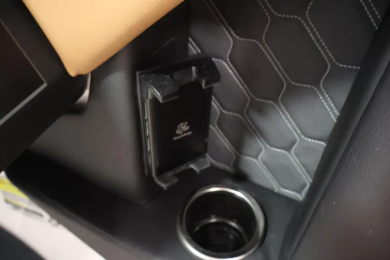 Slide: The Image of Interior detail of 2026 Four Winns H4 boat, featuring cup holder and phone holder. - 24