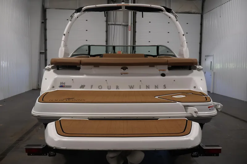 Slide: The Image of 2026 Four Winns H4 boat rear view in a garage setting. - 5