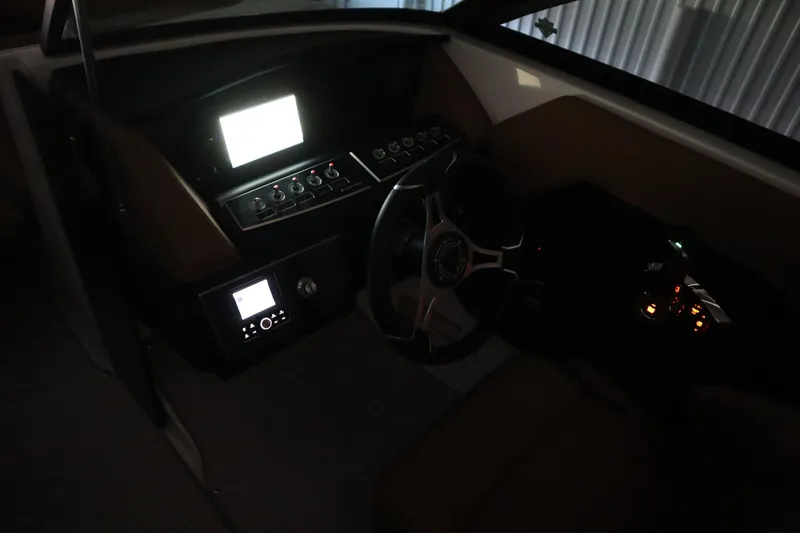 Slide: The Image of 2026 Four Winns H4 boat dashboard with illuminated controls and steering wheel. - 57