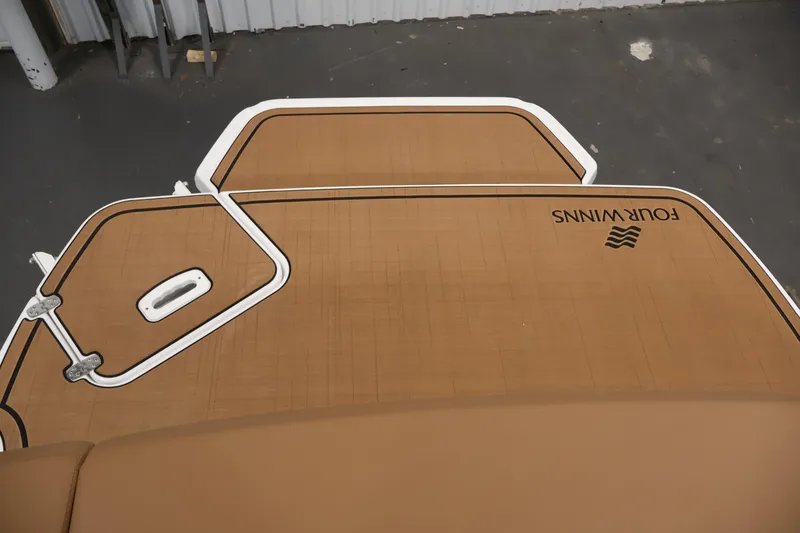 Slide: The Image of 2026 Four Winns H4 boat deck with brown finish and logo, viewed from above. - 46