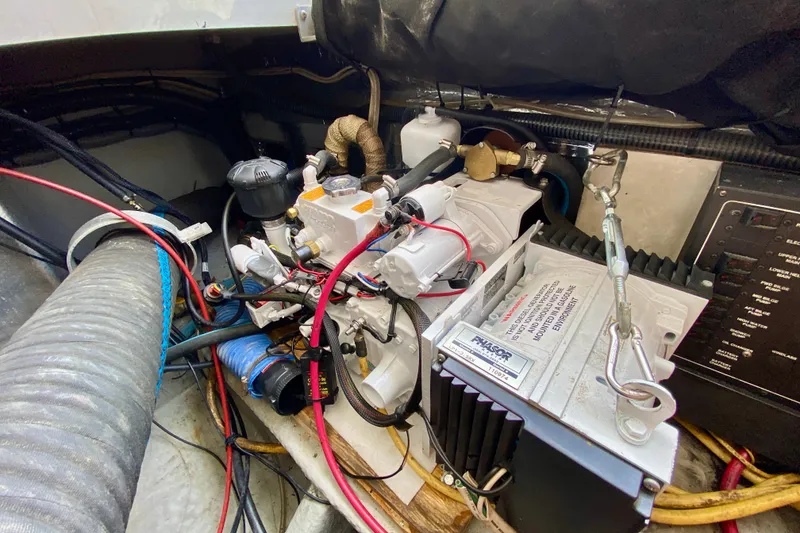 Slide: The Image of Engine compartment of a 2002 Mainship Pilot 34 boat, showcasing mechanical components and wiring. - 52