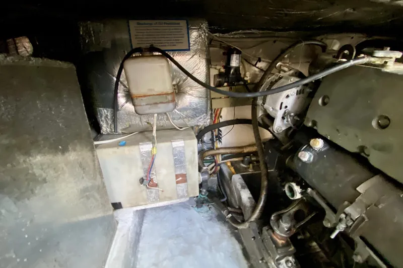 Slide: The Image of Engine compartment of a 2002 Mainship Pilot 34, showing mechanical components and wiring. - 57