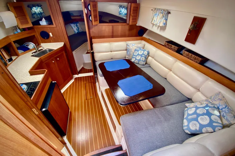 Slide: The Image of Interior of 2002 Mainship Pilot 34 yacht with cozy seating and wooden finishes. - 2