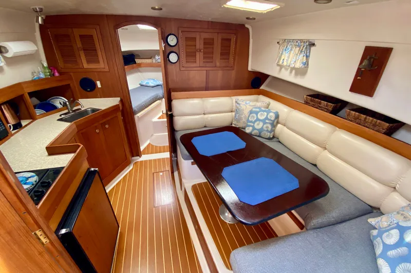 Slide: The Image of Interior of 2002 Mainship Pilot 34 yacht with cozy seating and compact kitchen area. - 18