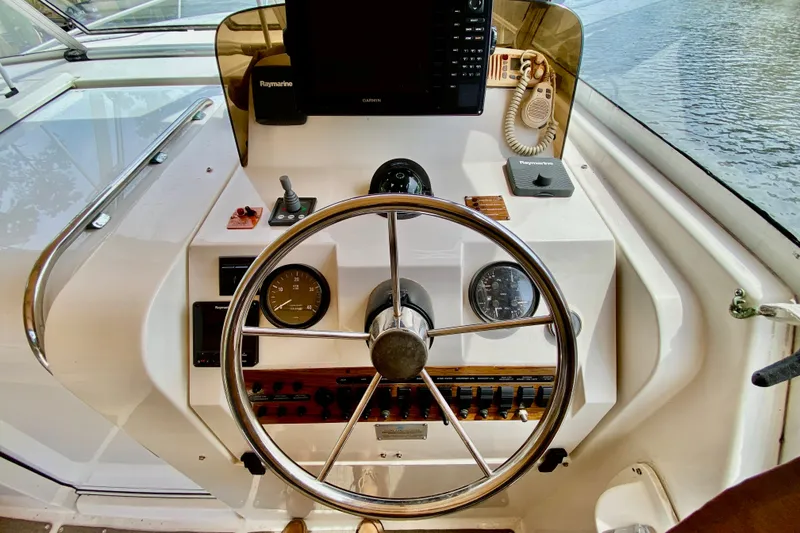 Slide: The Image of Helm of 2002 Mainship Pilot 34 with steering wheel, gauges, and navigation equipment. - 13