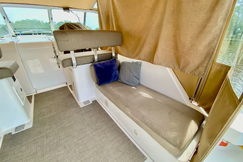 Slide: The Image of Interior of 2002 Mainship Pilot 34 boat with cushioned seating and curtains. - 9