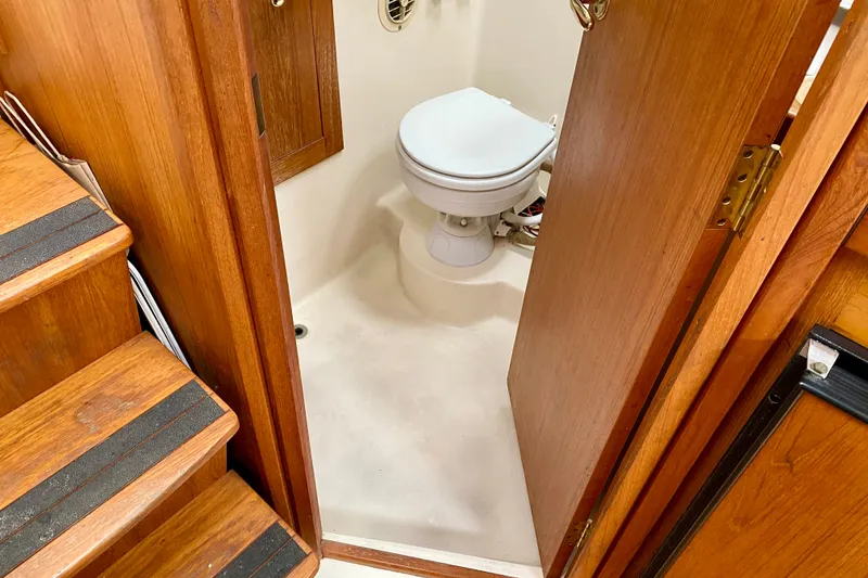 Slide: The Image of 2002 Mainship Pilot 34 boat bathroom with wooden door and steps. - 22