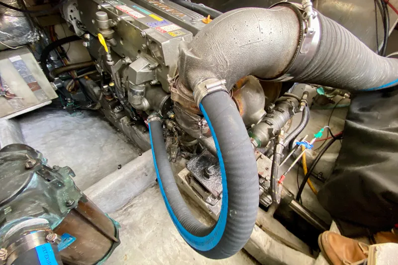 Slide: The Image of Engine compartment of a 2002 Mainship Pilot 34 boat, showcasing mechanical components and hoses. - 59