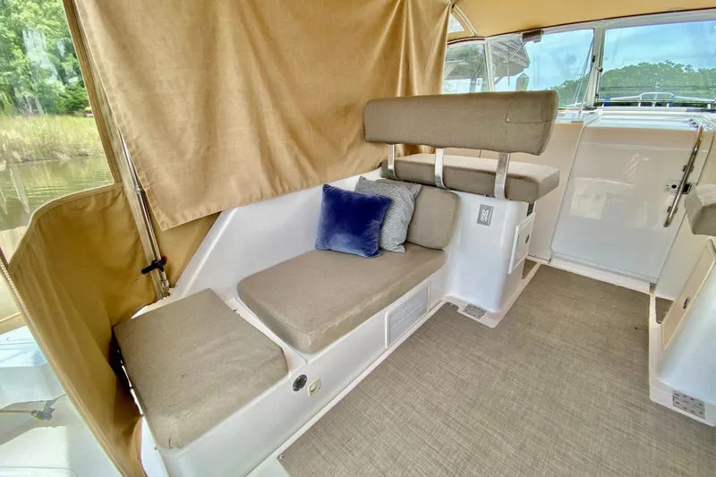 Slide: The Image of Interior of 2002 Mainship Pilot 34 boat with beige seating and blue cushion. - 8