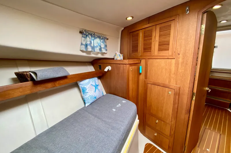 Slide: The Image of Cozy cabin interior of 2002 Mainship Pilot 34 with wooden cabinetry and nautical decor. - 36