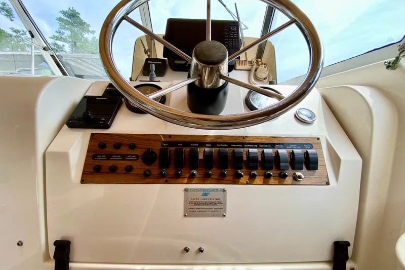 Slide: The Image of 2002 Mainship Pilot 34 helm with steering wheel and control panel. - 14