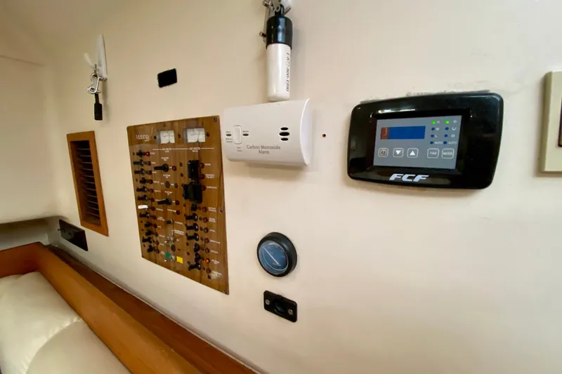 Slide: The Image of Control panel and carbon monoxide alarm inside a 2002 Mainship Pilot 34 boat cabin. - 38
