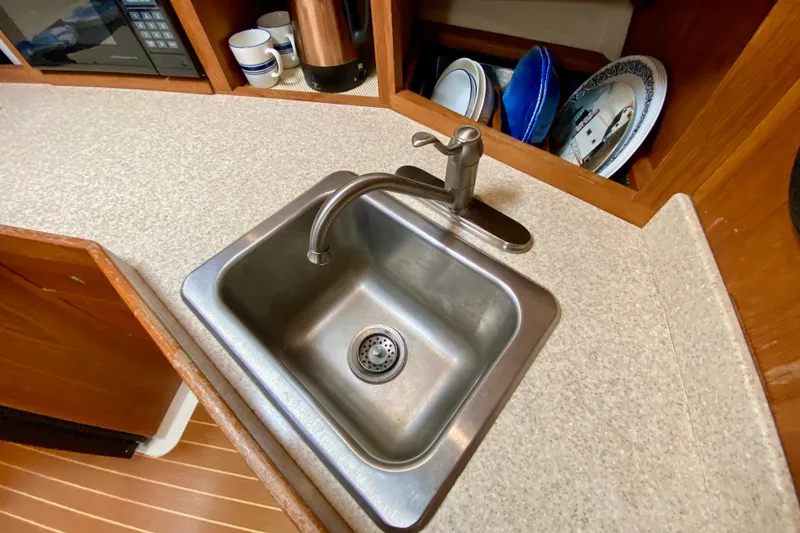 Slide: The Image of 2002 Mainship Pilot 34 galley sink with countertop and storage shelves. - 30