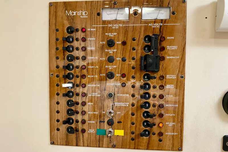 Slide: The Image of Electrical control panel of a 2002 Mainship Pilot 34 boat, featuring various switches and meters. - 37