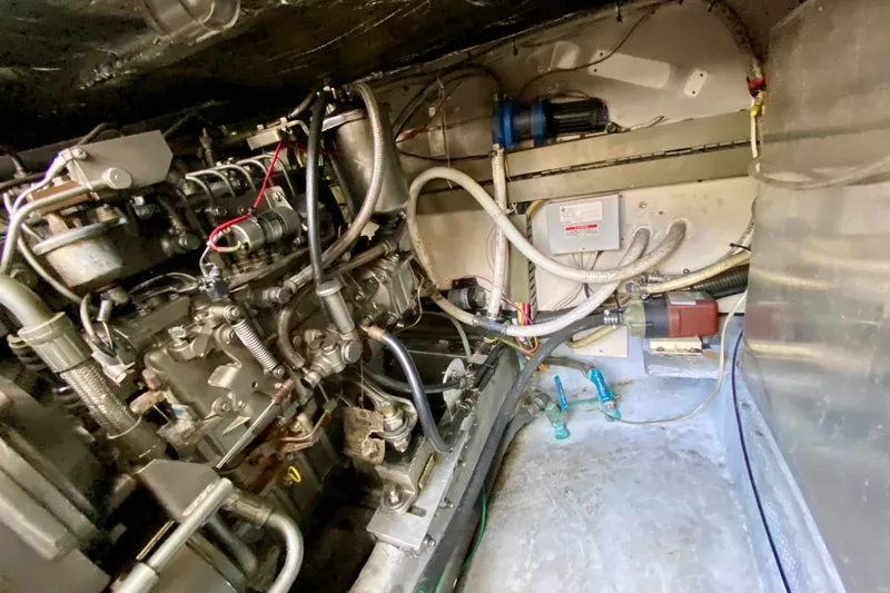 Slide: The Image of Engine compartment of a 2002 Mainship Pilot 34 boat, showcasing mechanical components and wiring. - 54