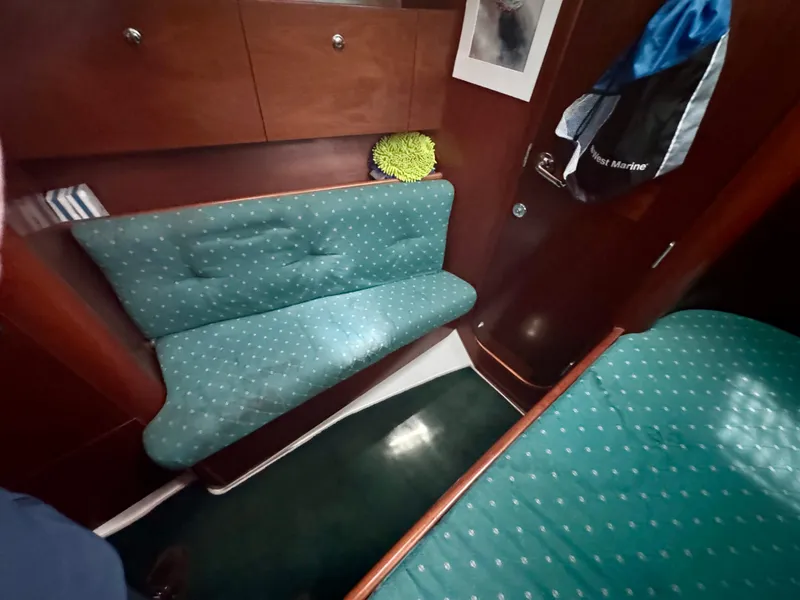 Slide: The Image of Cozy interior of 1996 Beneteau Oceanis 40 CC sailboat with teal seating and wooden cabinetry. - 9
