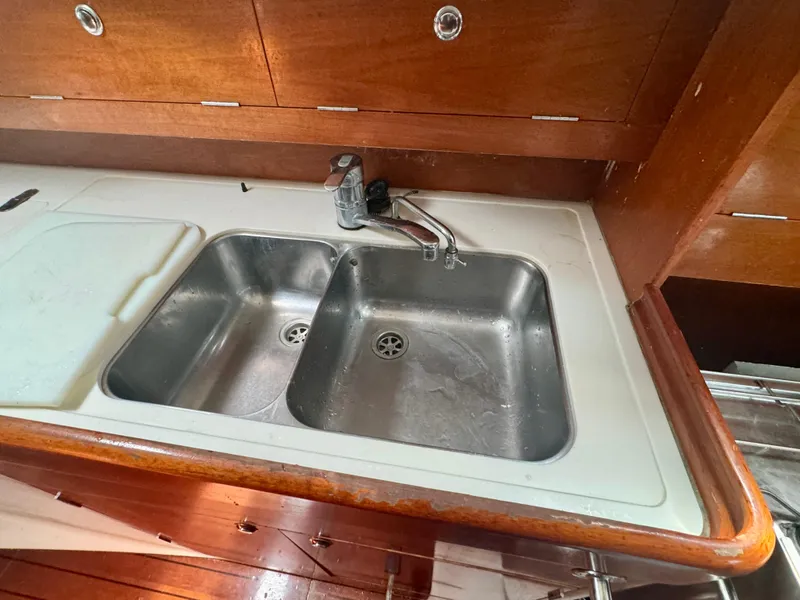 Slide: The Image of Galley sink in 1996 Beneteau Oceanis 40 CC yacht with wooden cabinetry. - 12