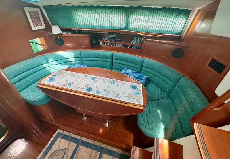 Slide: The Image of Cozy interior of 1996 Beneteau Oceanis 40 CC with green seating and wooden accents. - 5