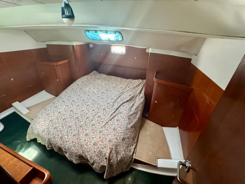 Slide: The Image of 1996 Beneteau Oceanis 40 CC cabin interior with bed and wooden cabinetry. - 17