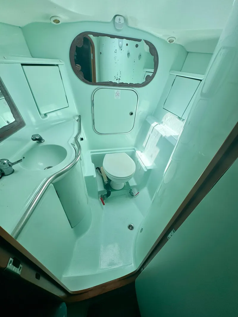 Slide: The Image of 1996 Beneteau Oceanis 40 CC bathroom with sink, toilet, and mirror. - 10