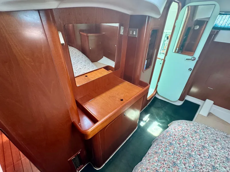 Slide: The Image of Interior of 1996 Beneteau Oceanis 40 CC yacht with wooden cabinetry and cozy bedding. - 18
