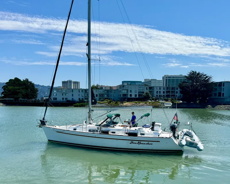 Slide: The Image of Beneteau Oceanis 40 CC sailboat from 1996 on calm water near urban buildings. - 2