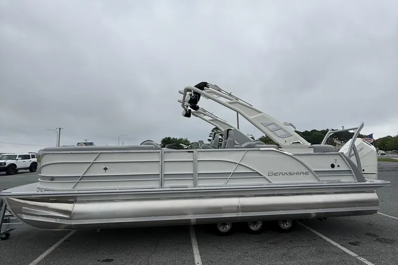 Slide: The Image of 2027 Berkshire 25RFX STS pontoon boat parked in a lot under cloudy skies. - 5