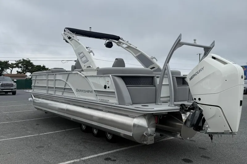 Slide: The Image of 2027 Berkshire 25RFX STS pontoon boat with Mercury outboard engine, parked on asphalt. - 6