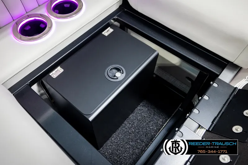 Slide: The Image of 2025 Avalon 2585 Excal VRBW boat interior with secure storage compartment and illuminated cup holders. - 28