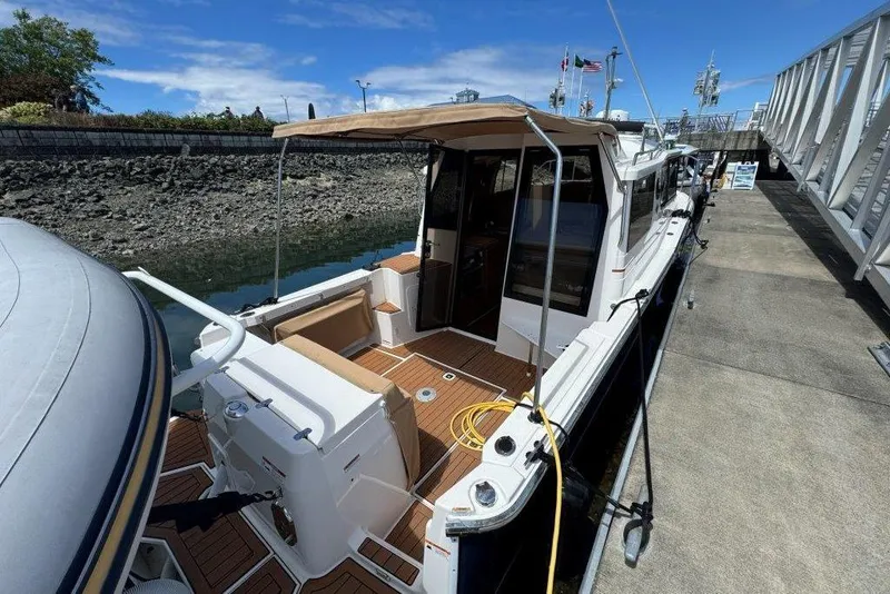 Slide: The Image of 2022 Ranger Tugs R-27 docked, showcasing spacious deck and modern design. - 3
