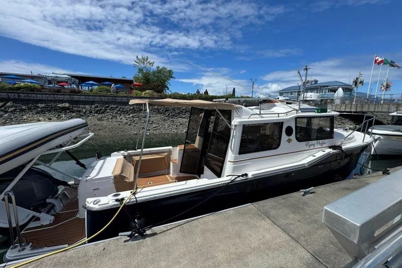 The Image of 2022 Ranger Tugs R-27 docked at marina under blue sky. - 1
