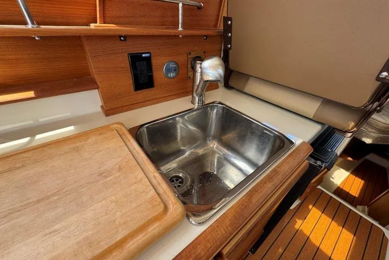 Slide: The Image of 2022 Ranger Tugs R-27 boat interior with wooden countertop and stainless steel sink. - 9