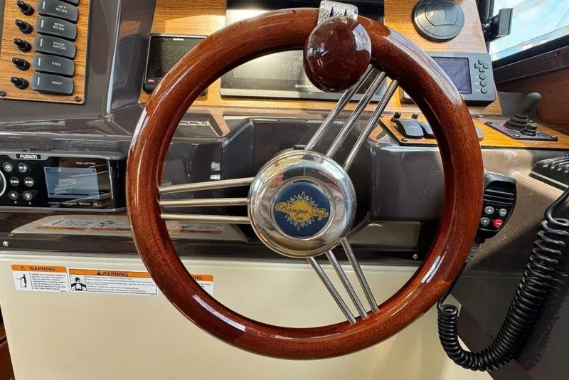 Slide: The Image of 2022 Ranger Tugs R-27 helm with wooden steering wheel and modern controls. - 17