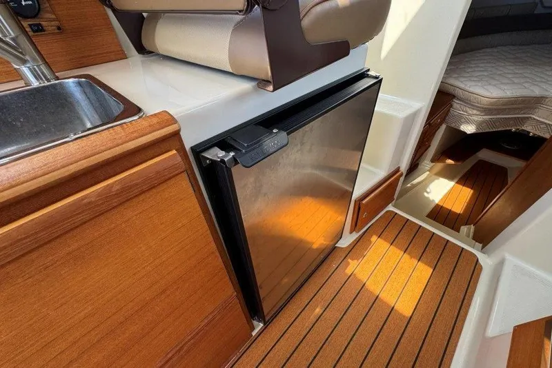 Slide: The Image of Interior of 2022 Ranger Tugs R-27 boat with kitchenette and compact fridge. - 12