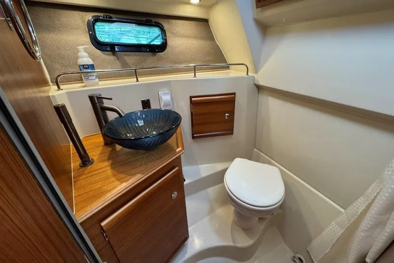 Slide: The Image of 2022 Ranger Tugs R-27 boat bathroom with modern sink and toilet. - 27