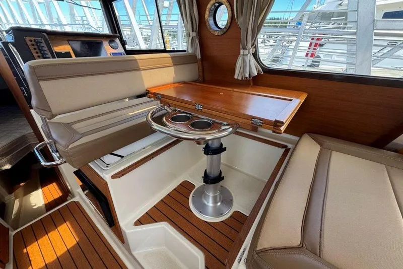 Slide: The Image of Interior of 2022 Ranger Tugs R-27 boat with seating and wooden table. - 6