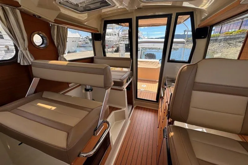 Slide: The Image of Interior of 2022 Ranger Tugs R-27 boat with beige seating and wood flooring. - 28