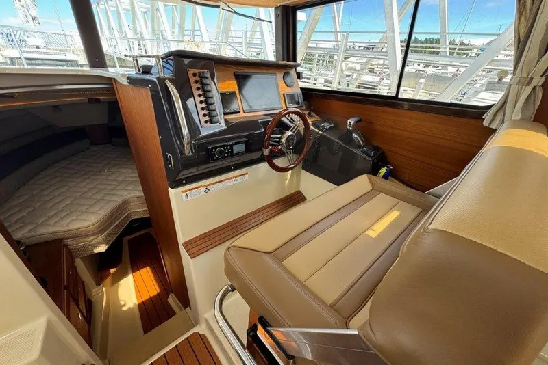 Slide: The Image of 2022 Ranger Tugs R-27 interior with helm, seating, and cabin view. - 14