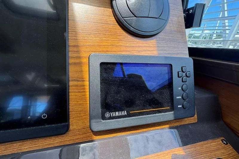 Slide: The Image of Yamaha display on 2022 Ranger Tugs R-27 dashboard, featuring wood paneling. - 18