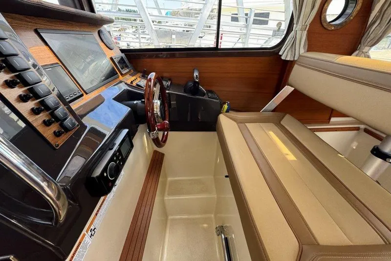 Slide: The Image of Interior of 2022 Ranger Tugs R-27 boat, featuring helm station and seating area. - 15
