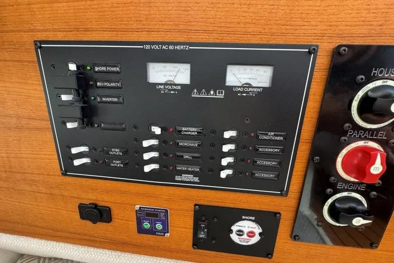 Slide: The Image of Electrical control panel on a 2022 Ranger Tugs R-27 boat, featuring switches and gauges. - 32