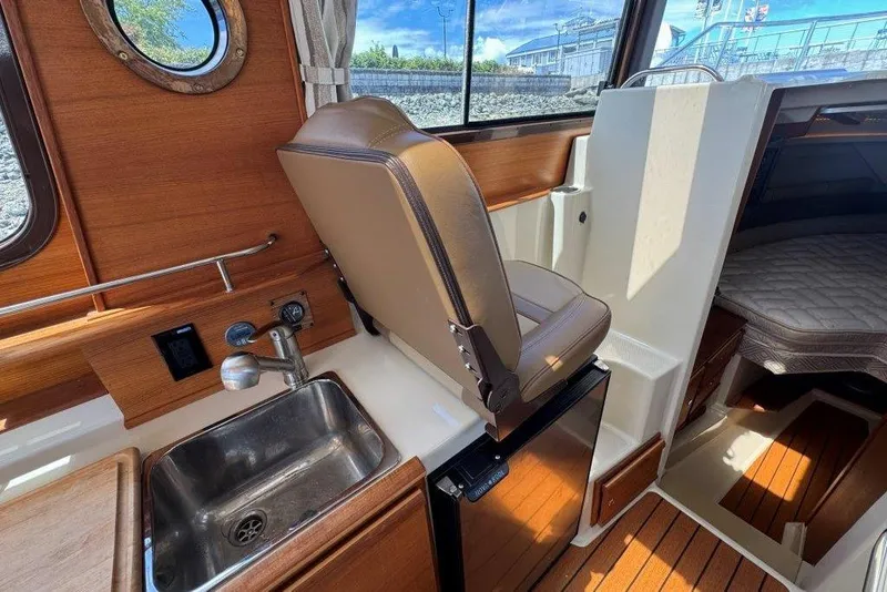 Slide: The Image of Interior of 2022 Ranger Tugs R-27 boat with sink, seat, and cabin view. - 13